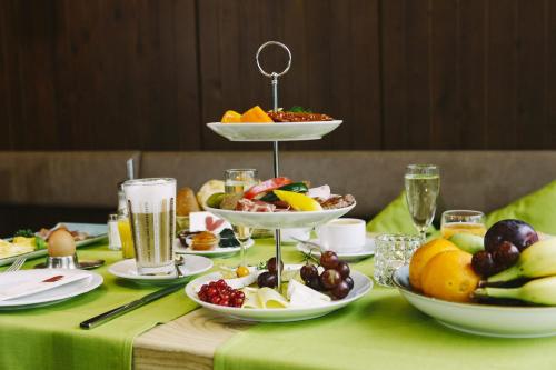 a table topped with plates of food and bowls of fruit at ParkHotel Fulda in Fulda