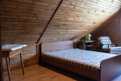 Cama en habitación con ático de madera en Chata Skrzata en Sztabin