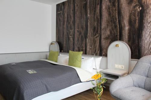 a bedroom with a bed and a chair at Hotel Rennsteig in Masserberg