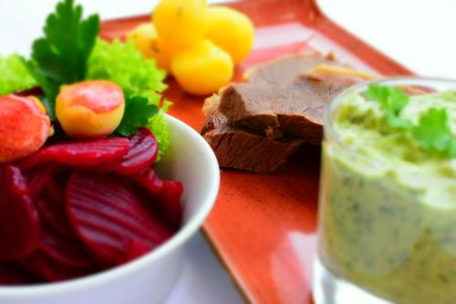 a plate of food with a bowl of dip and vegetables at ParkHotel Fulda in Fulda