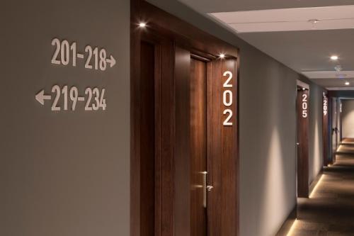 a row of wooden doors with numbers on the wall at B&B HOTEL Lisboa Montijo in Montijo
