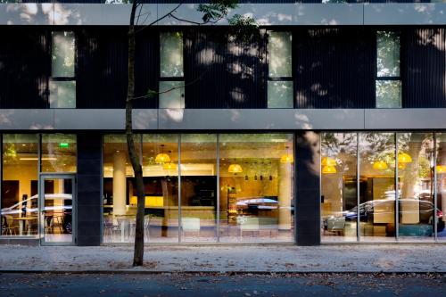 a building with a reflection of cars in the windows at B&B HOTEL Lisboa Montijo in Montijo