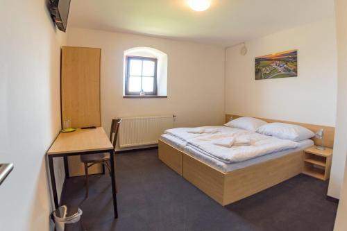 - une petite chambre avec un lit et un bureau dans l'établissement Hospoda na sýpce, à Kuks