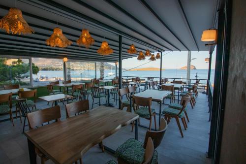 a restaurant with tables and chairs and a view of the ocean at Kiani Akti in Porto Rafti