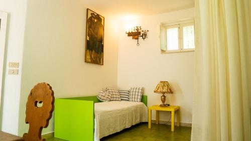 a small bedroom with a green bed and a window at Villaggio Placido in Taormina