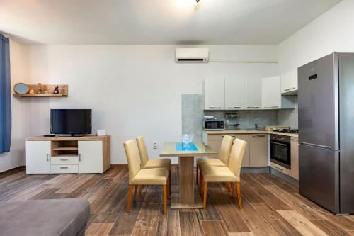 una cucina con tavolo, sedie e frigorifero di Apartments Smaila 1729 a Pola (Pula)