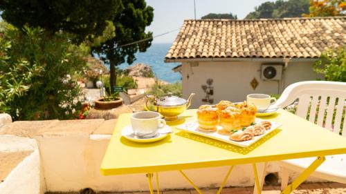 a yellow table with pastries and cups of coffee on it at Villaggio Placido in Taormina