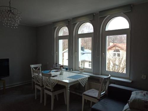 - une salle à manger avec une table, des chaises et 2 fenêtres dans l'établissement APARTAMENT DLA TURYSTÓW SOPOT, à Sopot