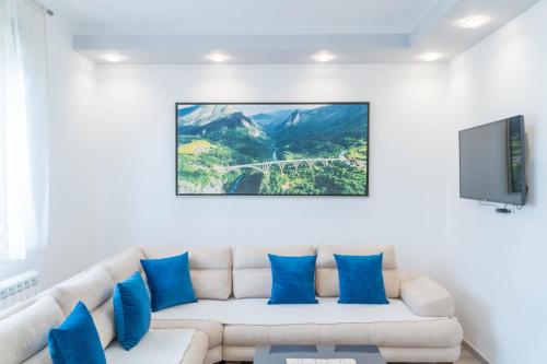 a living room with a white couch with blue pillows at Villa Lara in Žabljak