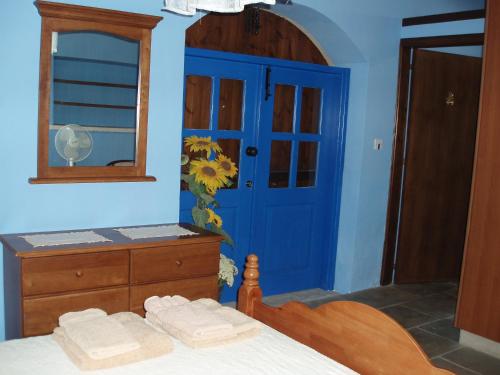 a blue bedroom with a bed and a blue door at Vasilion Agrotourism in Polis Chrysochous
