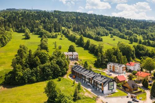 an aerial view of a house in a green field at Aparthotel Pod Stokiem z sauną i jacuzzi - Dream Apart in Szczyrk