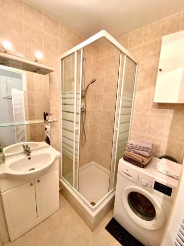 une salle de bain avec douche et lavabo et une machine à laver dans l'établissement L’IODE MARINE, à La Ciotat