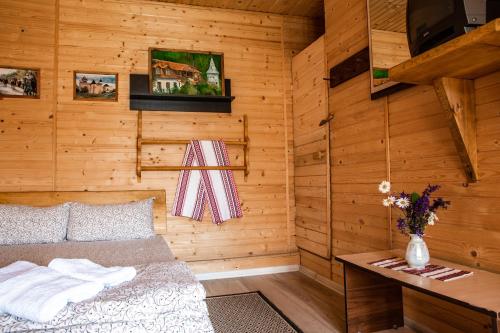 a bedroom with a bed in a wooden room at Bilya Richky Hotel in Kamianets-Podilskyi