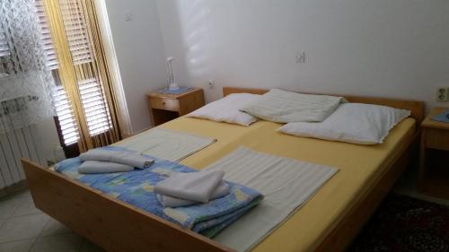 a bedroom with two beds with towels on them at Apartmani Ana Schon in Cres