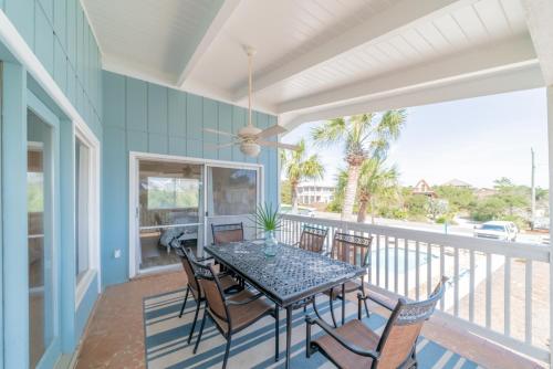 a patio with a table and chairs on a balcony at Cool Breeze Home in Inlet Beach
