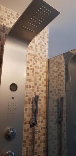 La salle de bains est pourvue d'une douche et de carrelage sur le mur. dans l'établissement Studio Naturiste 