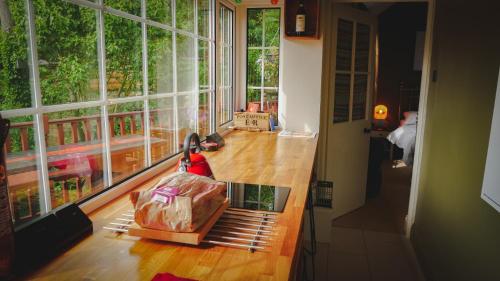 a room with a table with a bag and a large window at River Cottage at Old Post Office in Bardon Mill