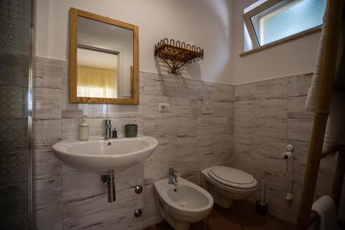 a bathroom with a sink and a toilet and a mirror at CasaPo' in Cetraro