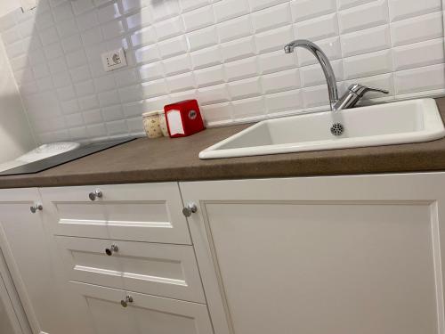 um balcão de cozinha com um lavatório e uma caneca vermelha em Domina Living Apartments - Presepe em Bisceglie