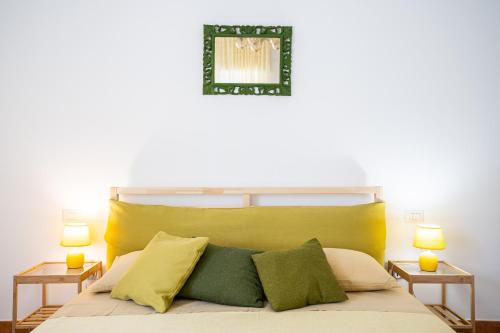a bedroom with a bed with a yellow headboard and two lamps at CasaPo' in Cetraro