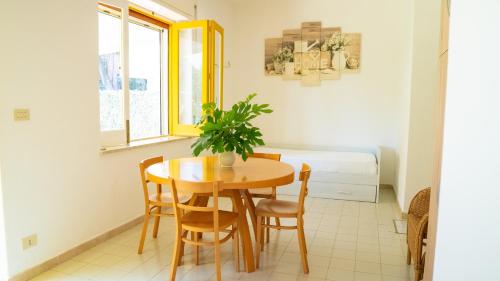 a dining room with a table and a potted plant at Villaggio Placido in Taormina