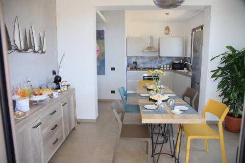 a kitchen with a table and yellow chairs at Valenti rooms & relax in Villaggio Mosè