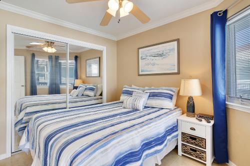 - une chambre avec 2 lits et un ventilateur de plafond dans l'établissement Seascape 2305 Condo, à Galveston