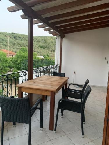 a wooden table and chairs on a balcony at Naiada Apartments Milina in Milína