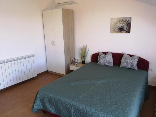 a bedroom with a bed with a green comforter at Marija in Šibenik