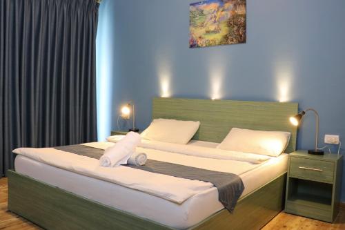 um quarto com uma cama grande e almofadas brancas em The Sydney Hotel em Amã