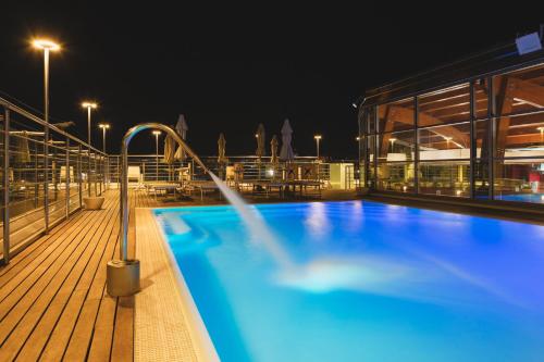 a swimming pool on a cruise ship at night at Hotel Mercure Siracusa in Siracusa
