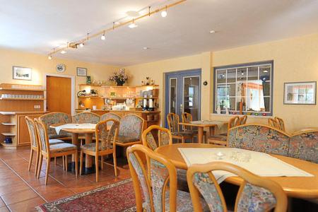 une salle à manger avec des tables et des chaises dans un restaurant dans l'établissement Hotel-Pension Störtebeker, à Bensersiel