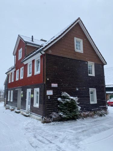 een groot houten gebouw met sneeuw op de grond bij Harzer Roller 1+2 in Braunlage