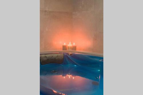 a bath tub with a candle and a lit candle at LOVEROOM REIMS in Reims