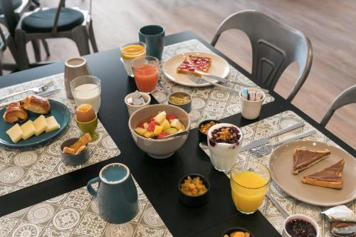 Una mesa con alimentos y bebidas para el desayuno. en Hotel So’Co by Happyculture, en Niza