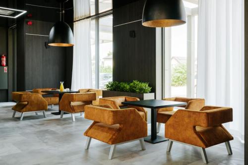 a dining room with tables and chairs and large windows at Aparton in Ustka