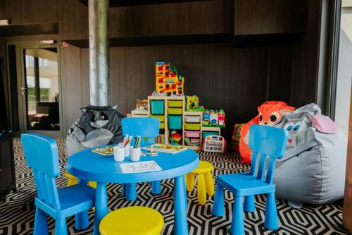 a room with two tables and chairs and a play area at Aparton in Ustka
