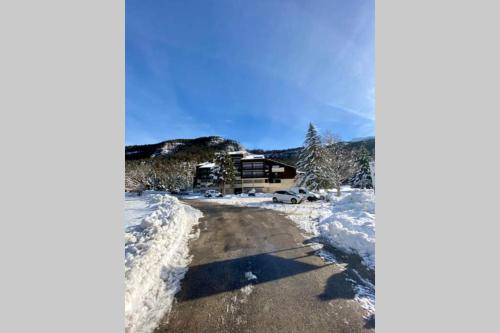 a snow covered road in front of a lodge at Appartement chaleureux - pied des pistes in Corrençon-en-Vercors