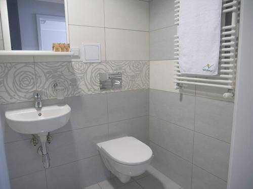 a white bathroom with a toilet and a sink at CKS Kraków (Centrum Konferencyjno-Szkoleniowe CS Natura Tour) in Kraków