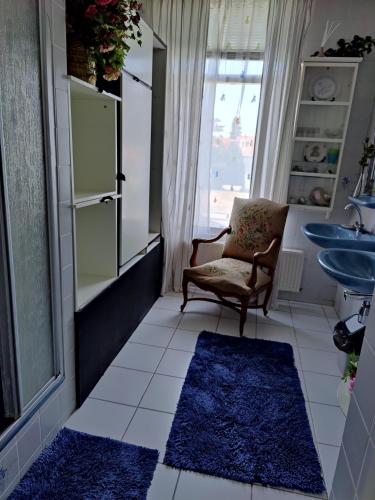 La salle de bains est pourvue d'une chaise et d'un lavabo. dans l'établissement Cosy appartement Wassenaar, à Wassenaar
