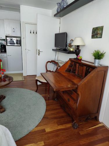 a living room with a wooden desk in a room at Cosy appartement Wassenaar in Wassenaar