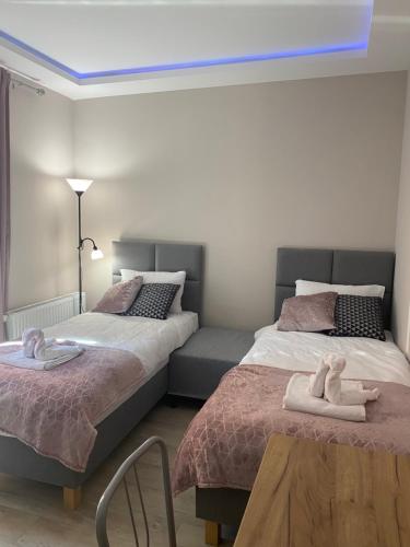 a bedroom with two beds and a table with towels at Aparthotel Riva in Zawiercie