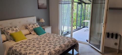 une chambre avec un lit et une porte coulissante en verre dans l'établissement bord de mer, à La Ciotat