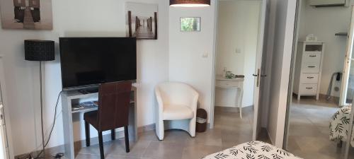 Cette chambre comprend un bureau avec une télévision et une chaise. dans l'établissement bord de mer, à La Ciotat