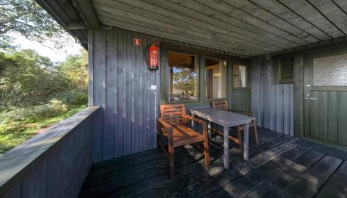 - une table et des chaises sur la terrasse couverte d'une maison dans l'établissement Isakssons Cottage 4, à Föglö