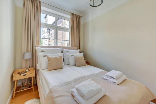 a bedroom with a white bed with two towels on it at Downtown Apartments Old Town Powroźnicza in Gdańsk