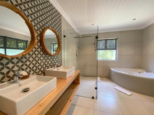 a bathroom with a tub and a sink and a tub and shower at Loerie Guest Lodge in George