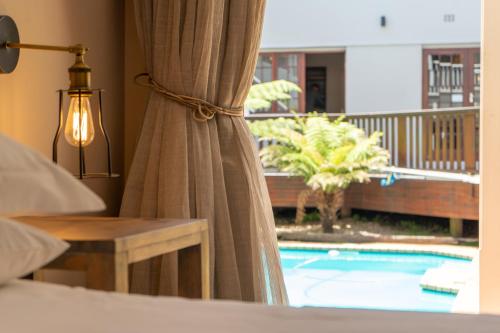 um quarto com uma cama e uma janela com uma piscina em Loerie Guest Lodge em George