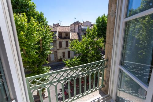 a balcony with a view of a city at Hôtel Le Relais de Poste Arles Centre Historique in Arles