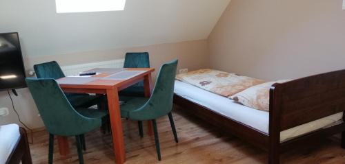a small room with a bed and a table and chairs at Apollo Vendégház in Edelény